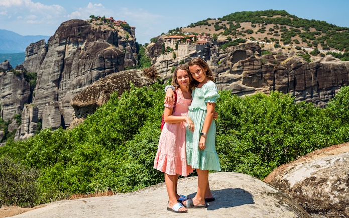 Two children standing on a rock with Meteora monasteries in the background, Thessaloniki tour.