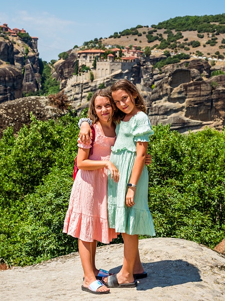 Two children standing on a rock with Meteora monasteries in the background, Thessaloniki tour.