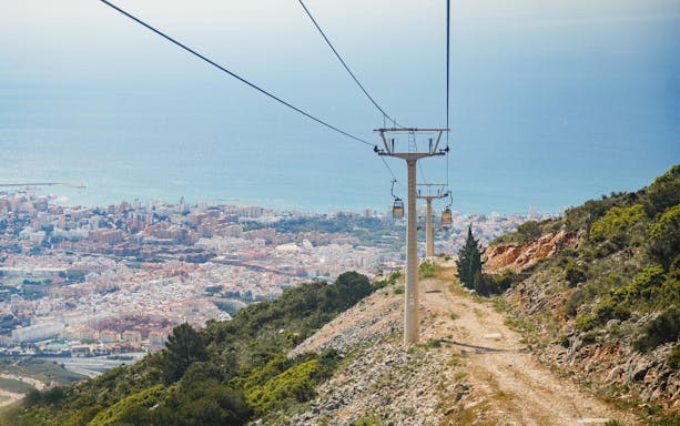 Benalmádena Cable Car ascending with city and sea view in the background.