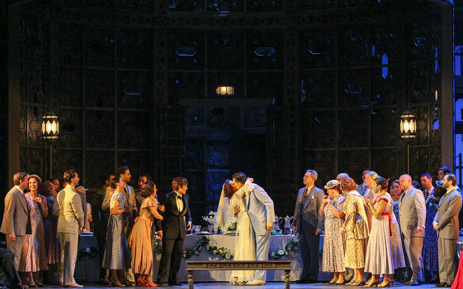 Wedding scene from Le Nozze Di Figaro opera with cast in period costumes on stage.