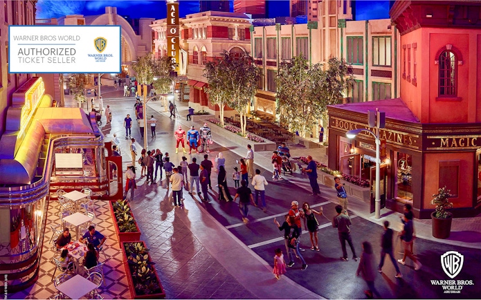 Visitors at Warner Bros. World Abu Dhabi interacting with costumed characters on a themed street.
