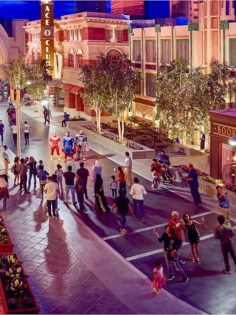 Visitors at Warner Bros. World Abu Dhabi interacting with costumed characters on a themed street.