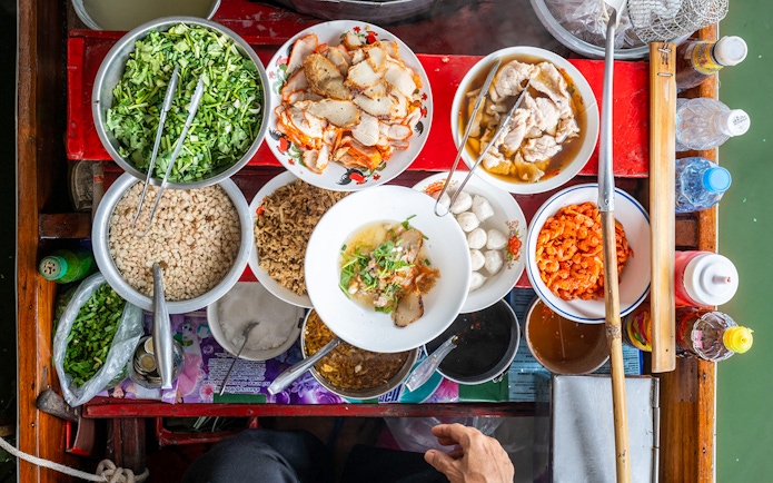 Assorted Thai dishes on a boat at Damnoen Saduak Floating Market.