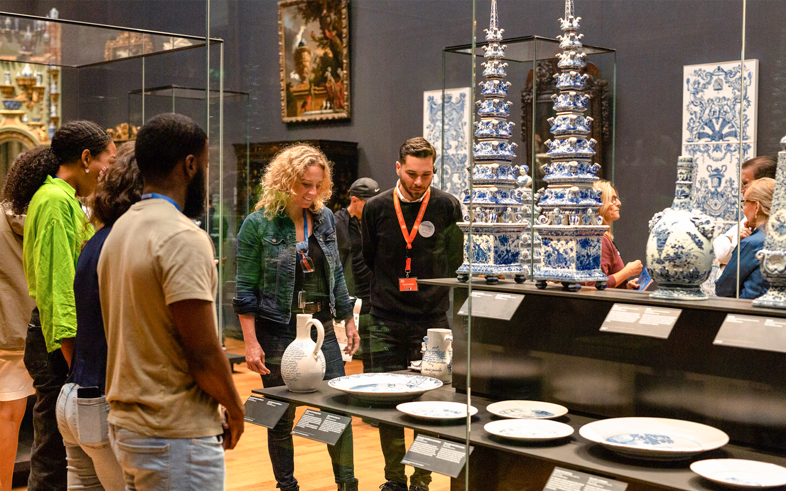 Visitors observing Delftware pottery on a guided tour at the Rijksmuseum, Amsterdam.