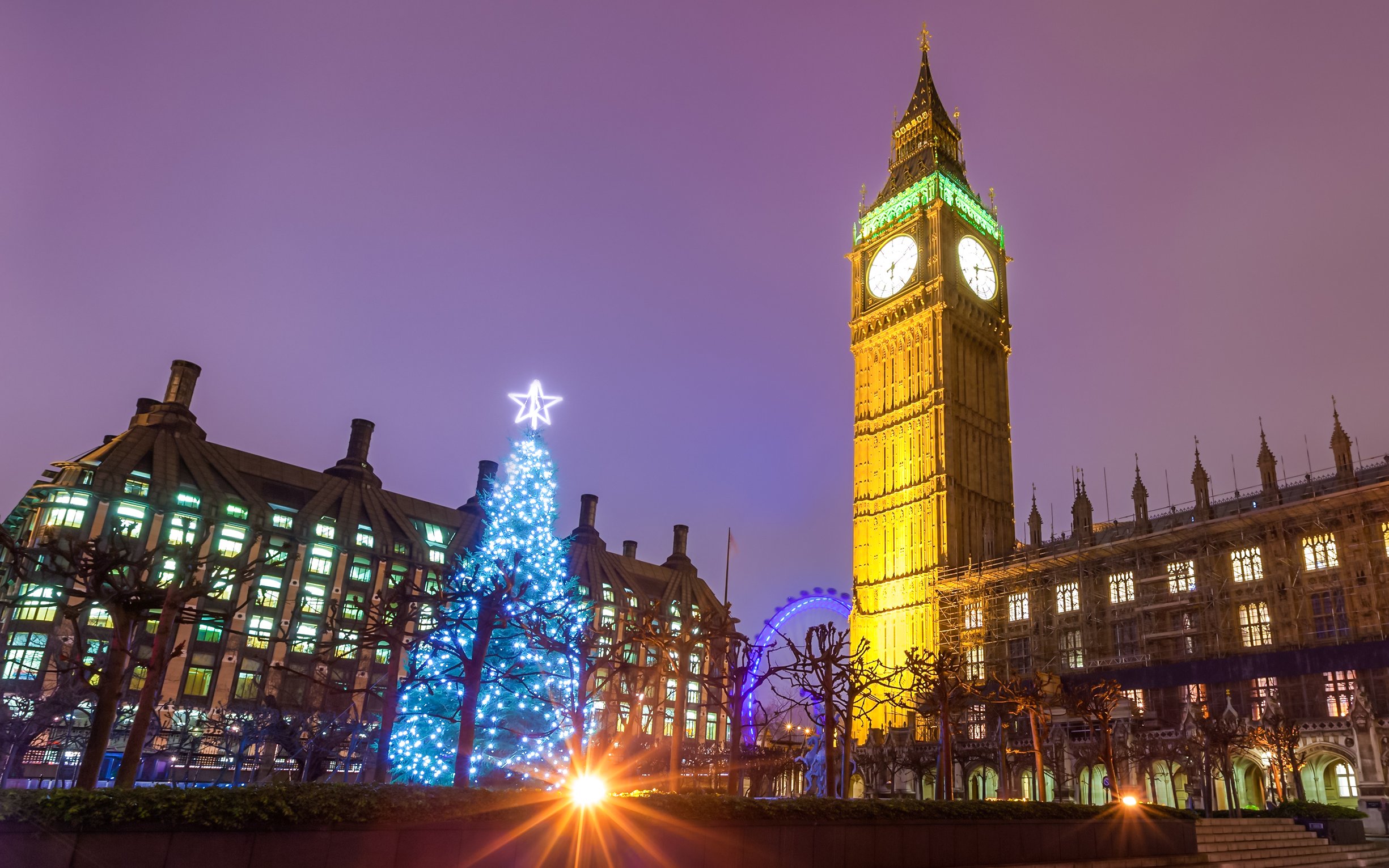 Big Ben and Christmas tree lights in London at night.