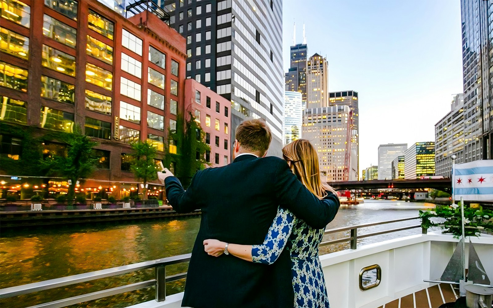 Couple on deck enjoying Chicago skyline during 90-minute scenic sunset Lake Michigan cruise.