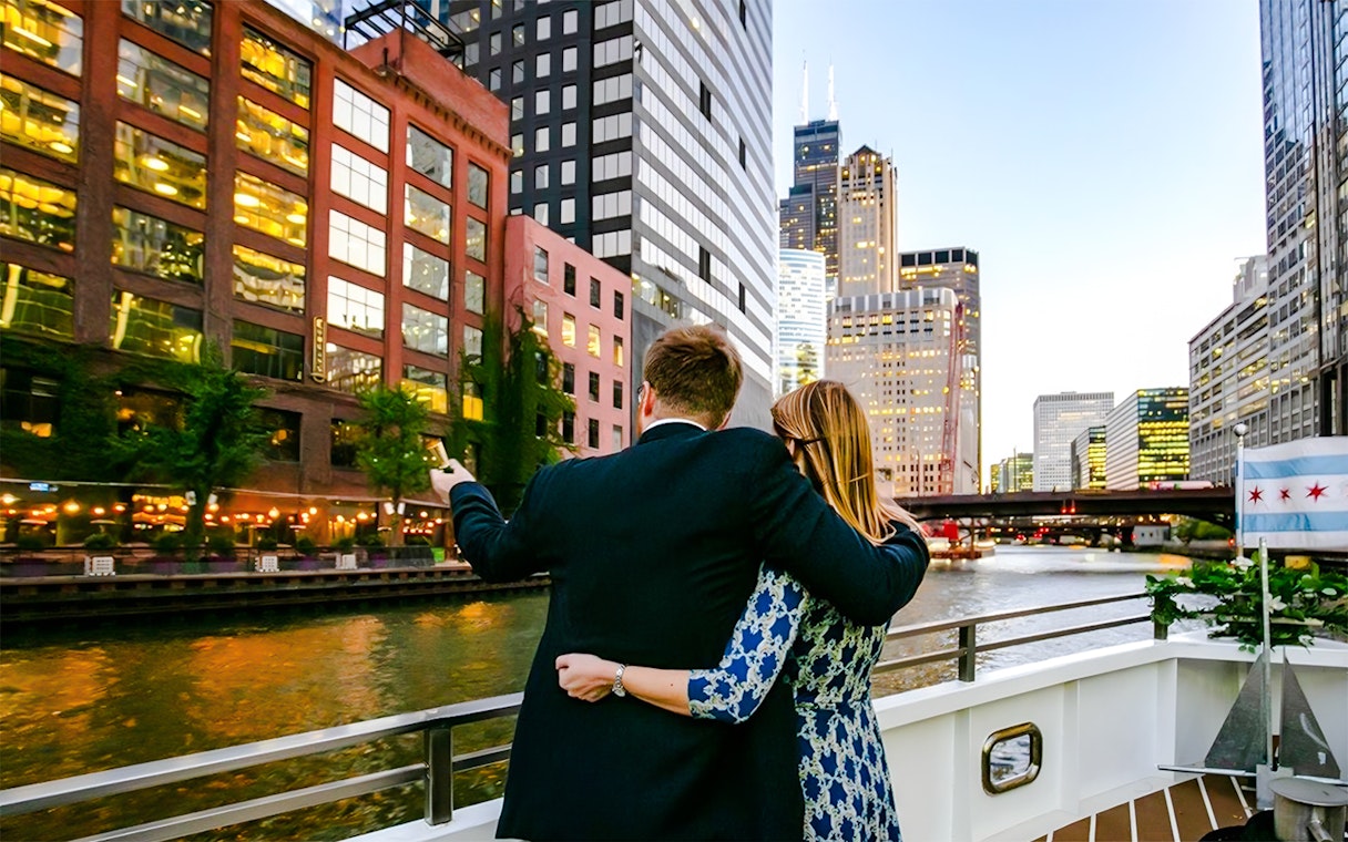 Couple on deck enjoying Chicago skyline during 90-minute scenic sunset Lake Michigan cruise.