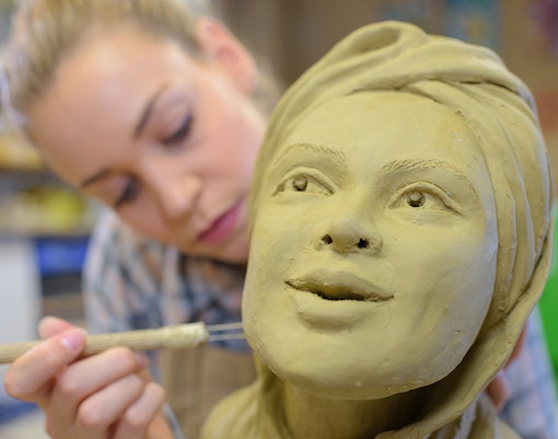 A lady making a wax statue