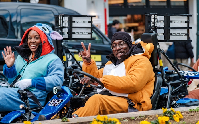 Go-kart riders in costumes enjoying Shibuya, Tokyo tour.