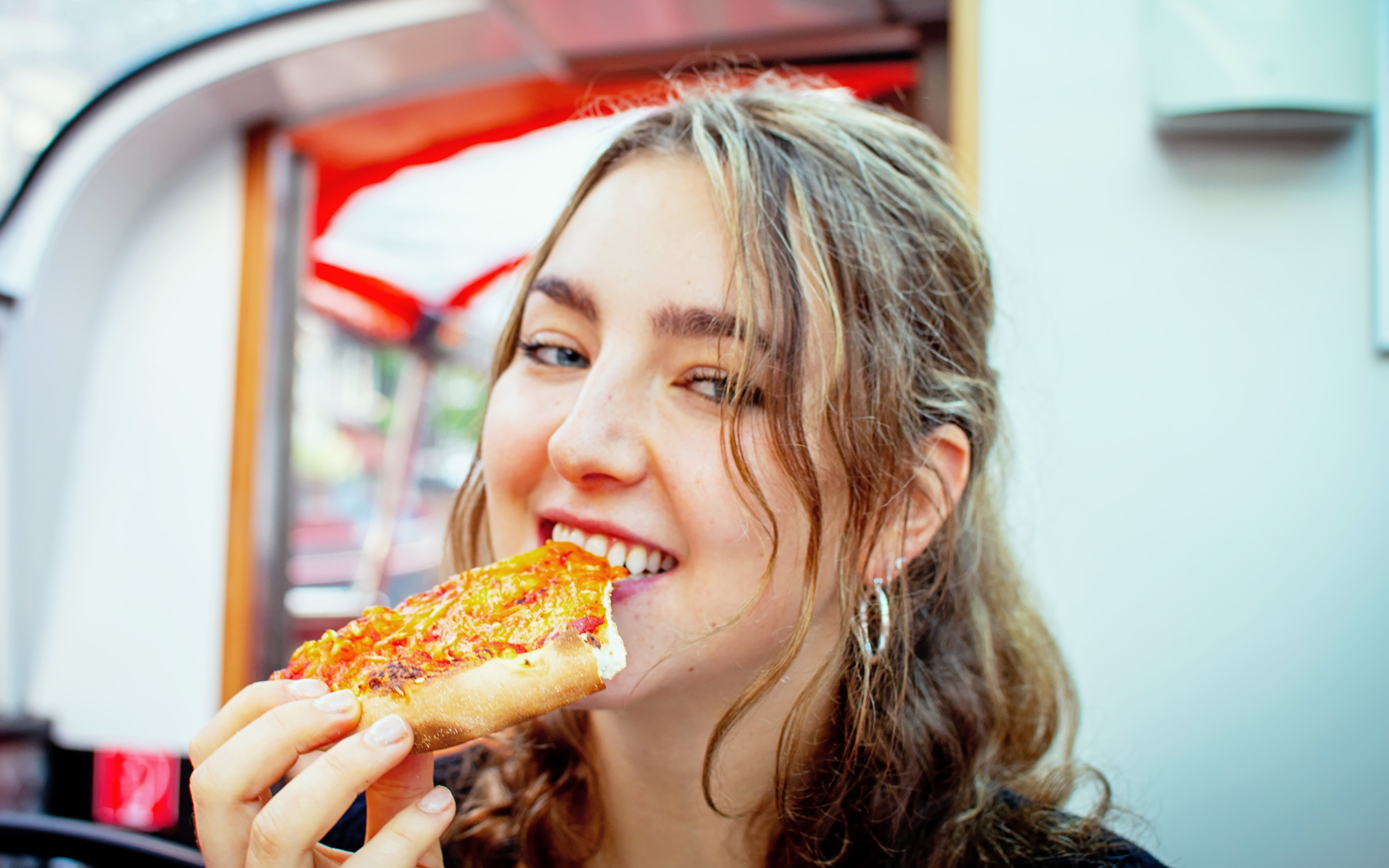 Girl enjoying pizza on Stockholm pizza cruise.