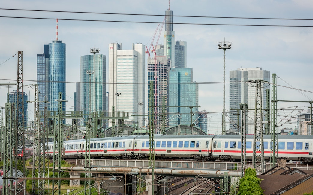 Train passing through Frankfurt with city skyline in the background, Germany.