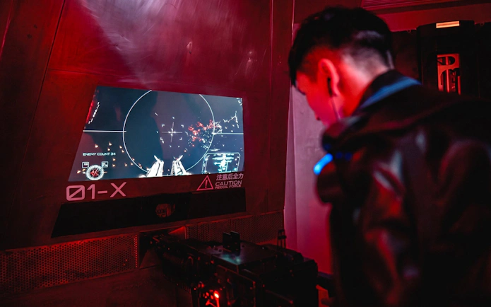 Person interacting with a futuristic control panel at AI Dream Immersive Theater.