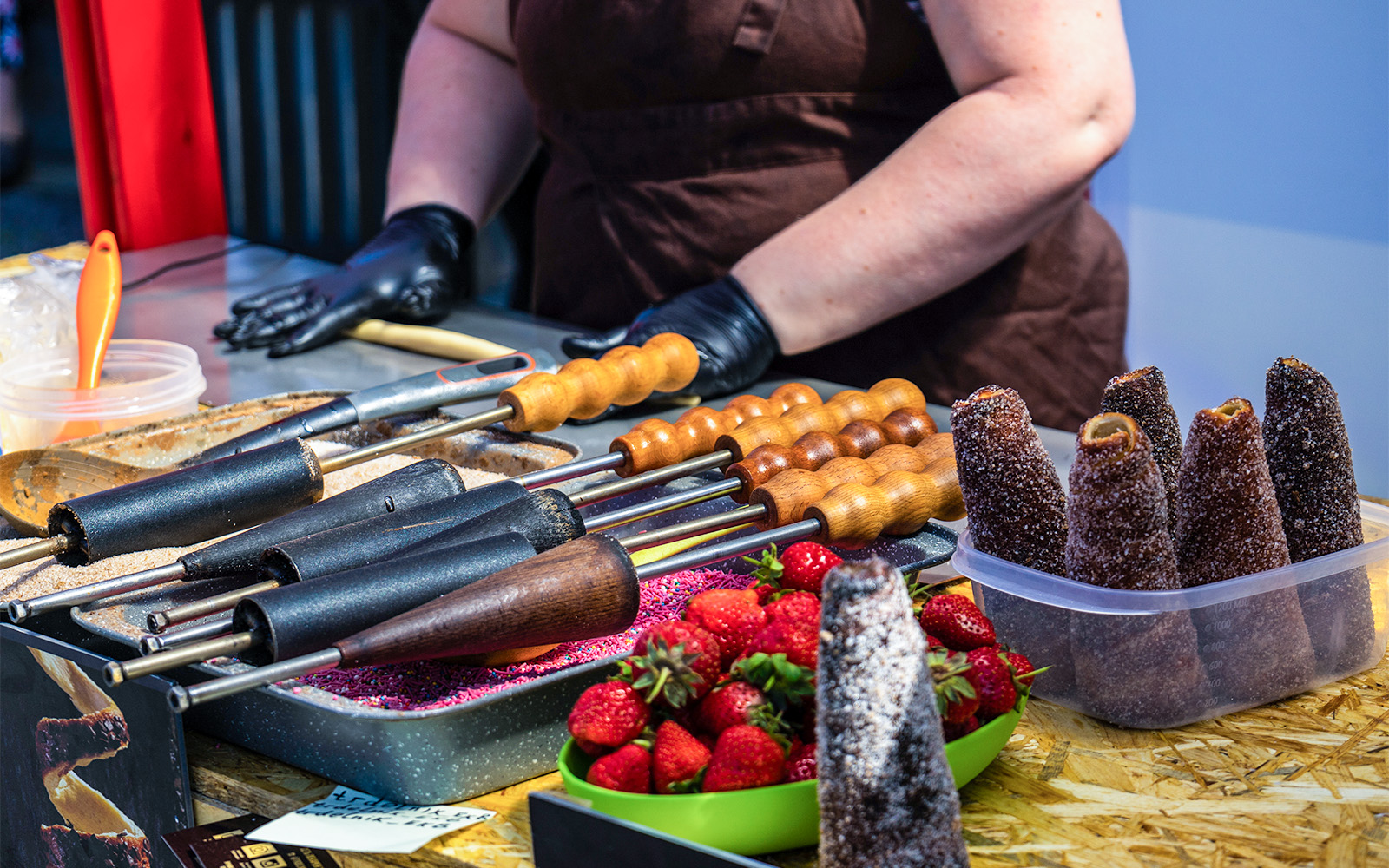 Churros preparation at a Madrid street market with strawberries and cooking tools.