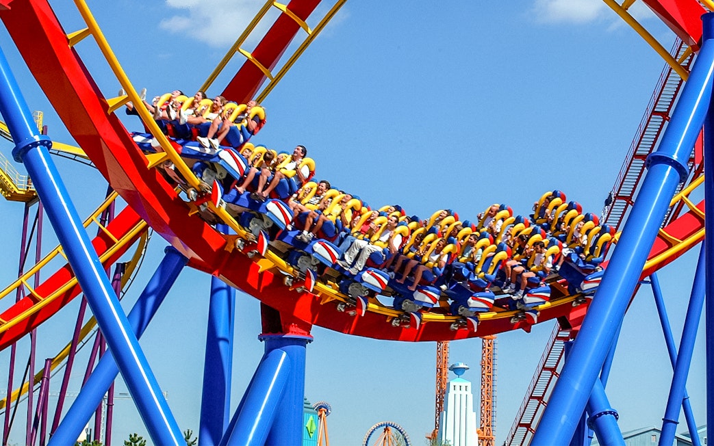 Visitors riding a colorful roller coaster at Parque Warner Madrid.