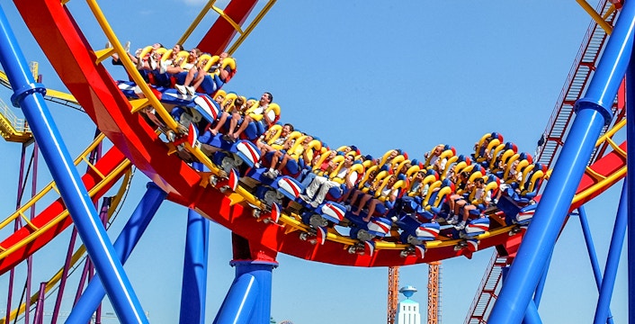 Visitors riding a colorful roller coaster at Parque Warner Madrid.