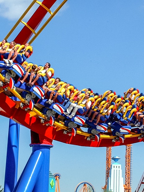 Visitors riding a colorful roller coaster at Parque Warner Madrid.