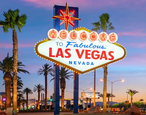 Welcome to Fabulous Las Vegas sign with palm trees at sunset.