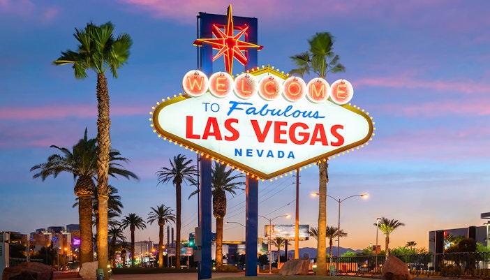 Welcome to Fabulous Las Vegas sign with palm trees at sunset.