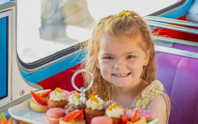Child enjoying treats on Peppa Pig themed bus tour, Brigit’s Afternoon Tea Bus Tour.
