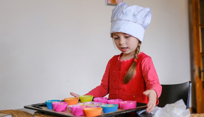 Child engaging in a cooking activity in a modern kitchen setting.