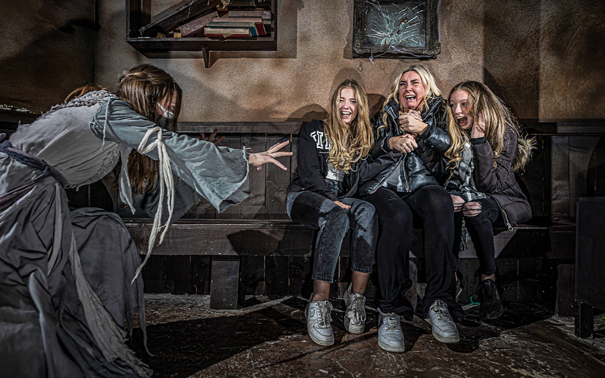 Visitors react to a costumed actor at the London Dungeon VIP experience.