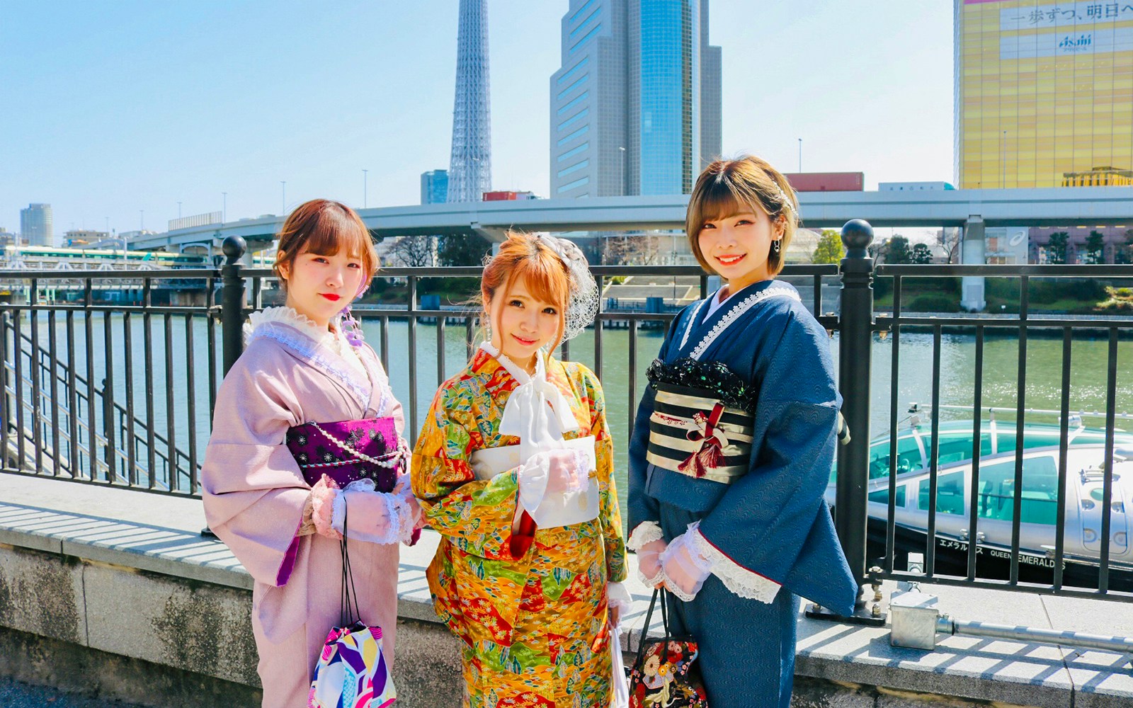 Visitors in kimonos posing in front of Tokyo Skytree.