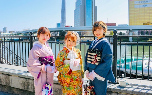 Three people in kimonos with Tokyo Skytree in the background.