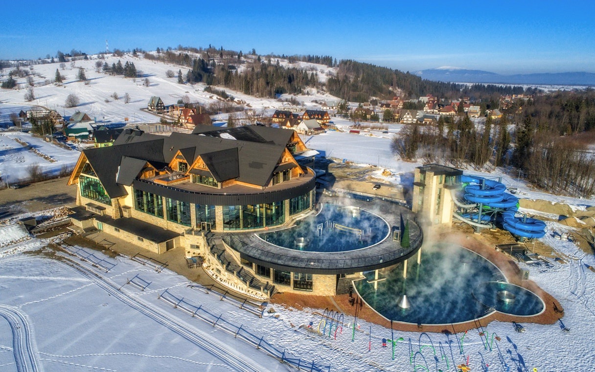 Chocholow Thermal Baths with snow-covered landscape and water slides in Poland.