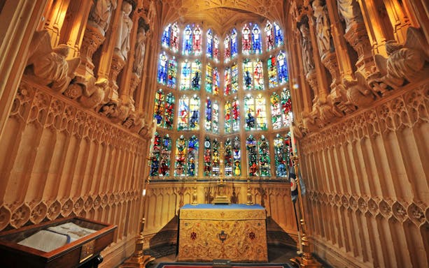 Stained glass windows and ornate altar inside Westminster Abbey, London.