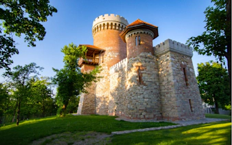 Historic fortress tower in Bucharest surrounded by trees, part of Dracula's Secret Journal tour.