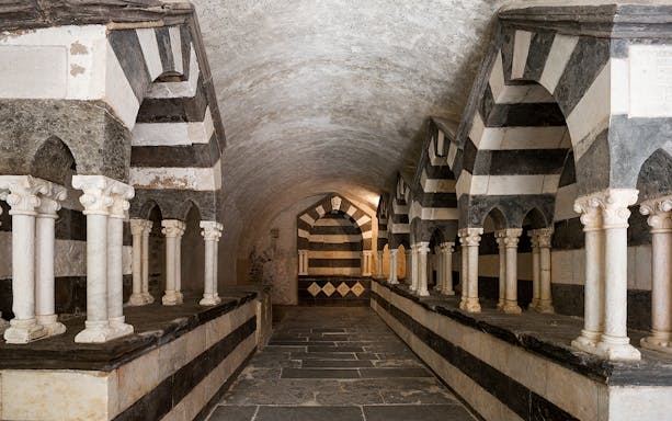 Abbazia di San Fruttuoso interior with striped arches and columns, Genoa, Italy.