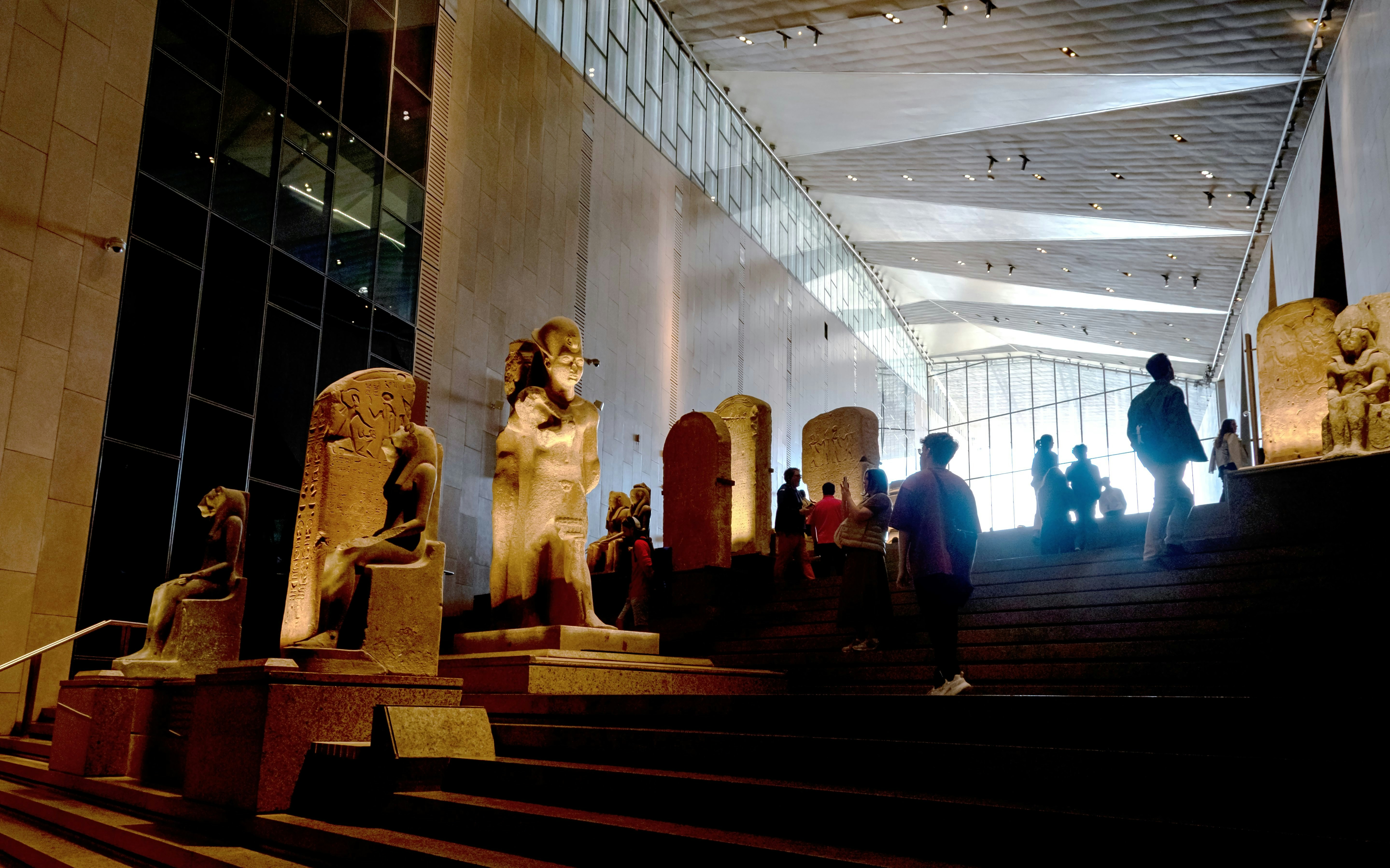 Grand Staircase with pharaonic statues and artifacts, Grand Egyptian Museum atrium.