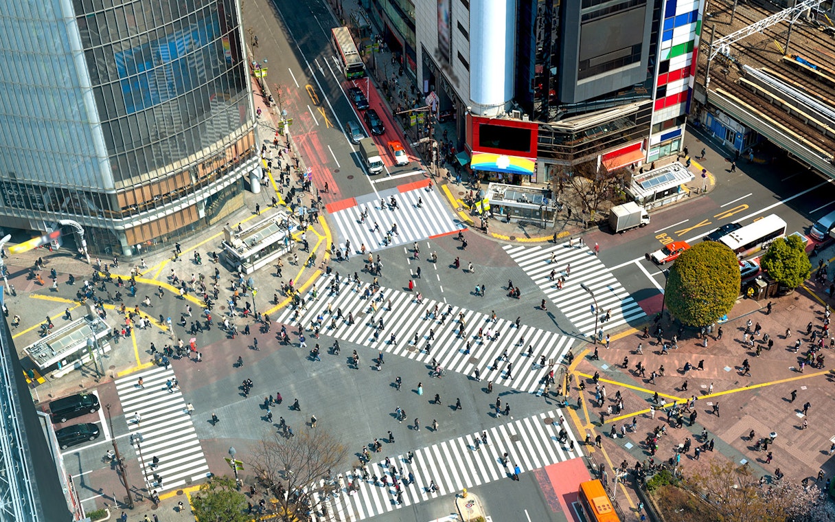 Shibuya Crossing in Tokyo bustling with pedestrians from an aerial view.