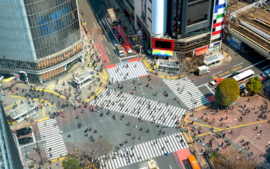 Shibuya Crossing in Tokyo bustling with pedestrians from an aerial view.