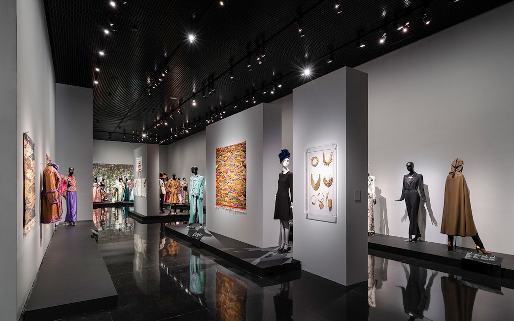 Fashion exhibit at YSL Museum in Marrakech showcasing designer clothing and accessories.