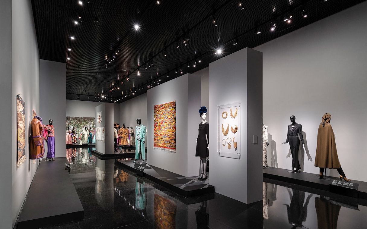 Fashion exhibit at YSL Museum in Marrakech showcasing designer clothing and accessories.