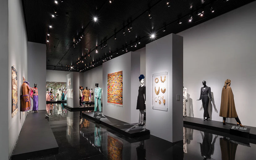 Fashion exhibit at YSL Museum in Marrakech showcasing designer clothing and accessories.