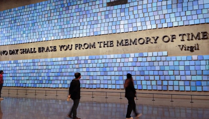 Visitors at the 9/11 Memorial in New York City, viewing the reflecting pools and engraved names.
