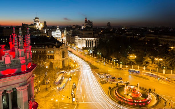 Plaza de Cibeles in Madrid, Spain, illuminated at night with city lights.