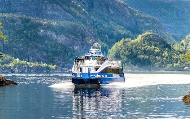 Mostraumen Fjord Cruise boat navigating through narrow fjord with steep cliffs in Norway.