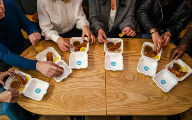 People enjoying fried chicken with dipping sauces on a Street Food Tour in South Lake Union.
