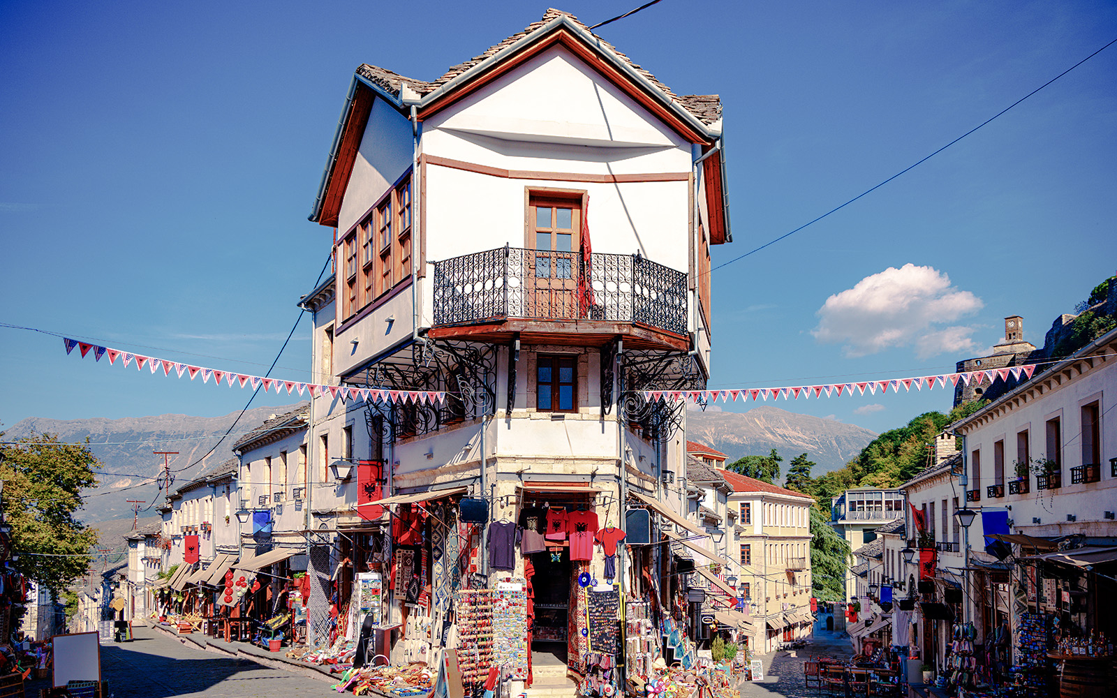 Historic bazaar street in Gjirokaster, Albania, with traditional Ottoman architecture and market stalls.