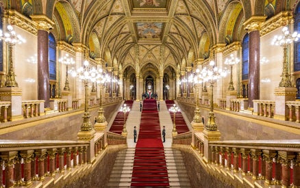 Hungarian Parliament grand staircase with ornate ceiling and red carpet in Budapest.
