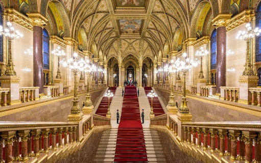 Hungarian Parliament grand staircase with ornate ceiling and red carpet in Budapest.