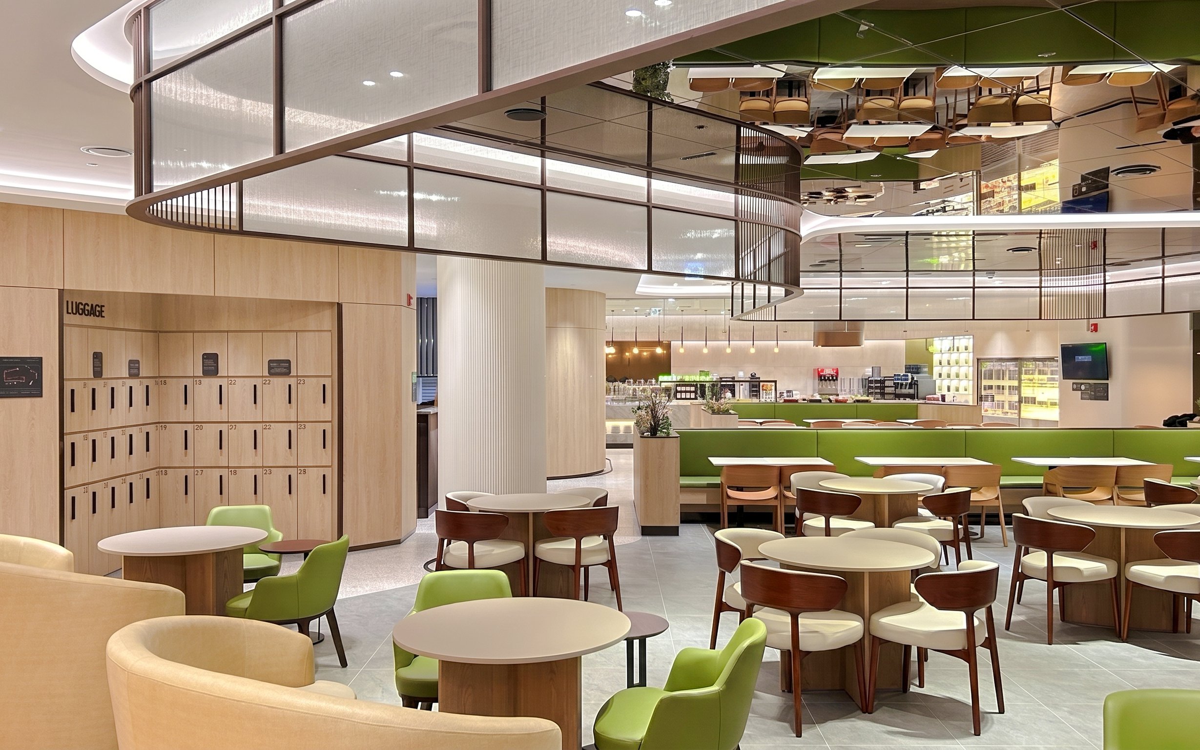 Sky Hub Lounge West seating area with tables, chairs, and luggage lockers.