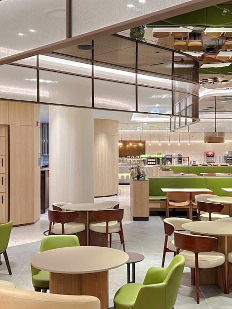 Sky Hub Lounge West seating area with tables, chairs, and luggage lockers.