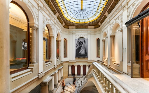 Interior of Museum of Forbidden Art with large portrait and ornate architecture.