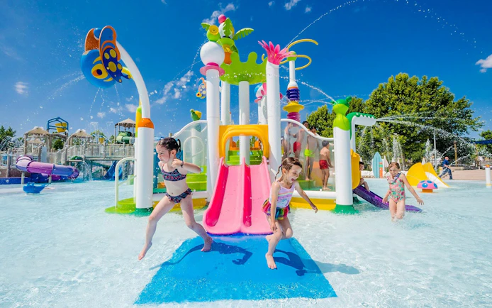 Children playing on colorful water slides at Parque Warner Beach.