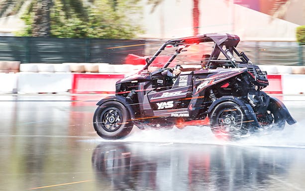 Polaris vehicle drifting on wet track at YAS Marina Circuit.