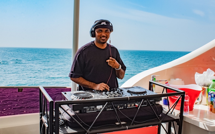 DJ performing on Superyacht TriDeck Cruise with ocean backdrop.